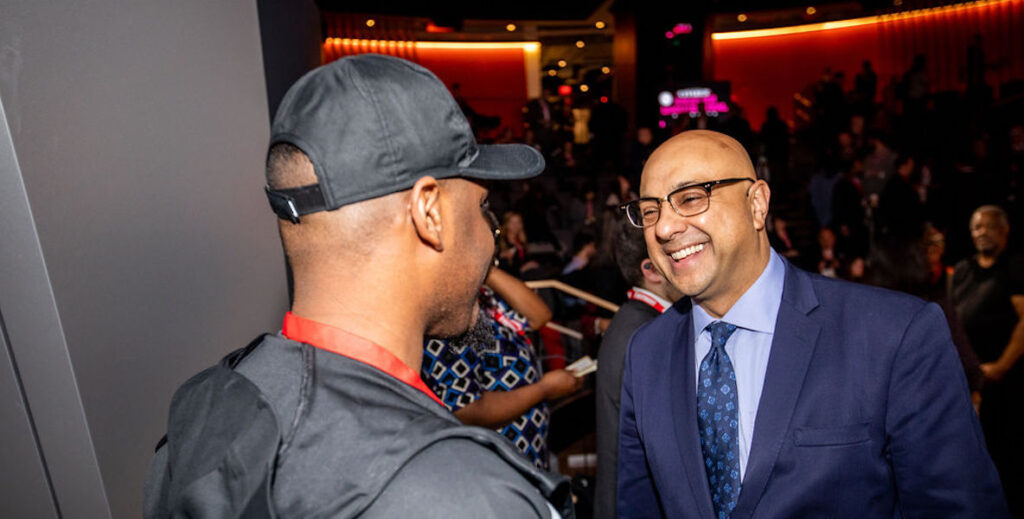 MSNBC host Ali Velshi smiles and shakes a fan's hand at an event in Philadelphia.