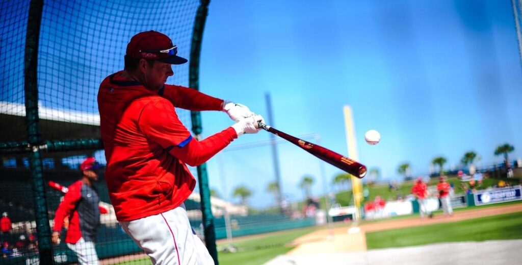 A Philadelphia Phillies player hits a ball with a bat.