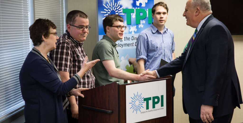 Graduates from The Precisionists, a company that readies people with autism for jobs in which they'll thrive, shake hands with a potential employer.
