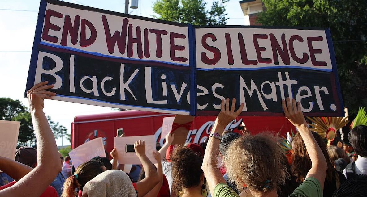 Protests erupt across the nation following the death of George Floyd. Here, rioters hold up a sign reading "End White Silence. Black Lives Matter."