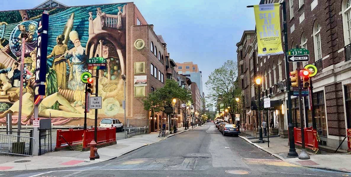 Looking east from the corner of 13th and Locust streets in Philadelphia, with a vibrant mural on the left. This is the Philadelphia Gayborhood.