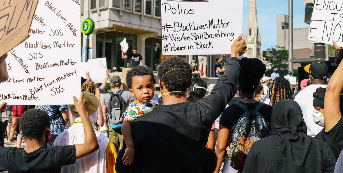 A young boy looks behind his father's shoulder at a Black Lives Matter protest in Philadelphia.