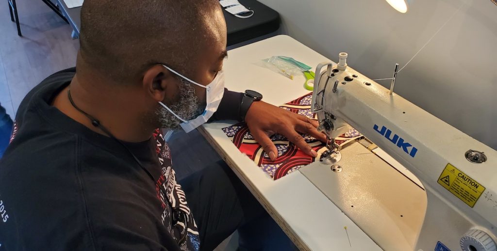 A volunteer with mask on Philly sews a mask for frontline workers