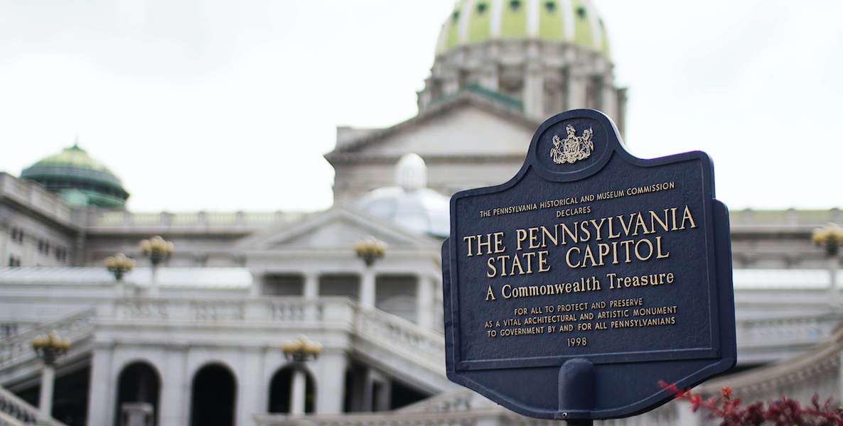 A sign notes the location of the Pennsylvania State Capitol, which rises in the background