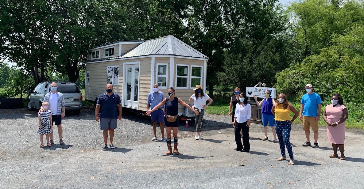 Housing advocates in Philadelphia stand outside a tiny house, part of a community effort to supply homes to people in the city who need them.