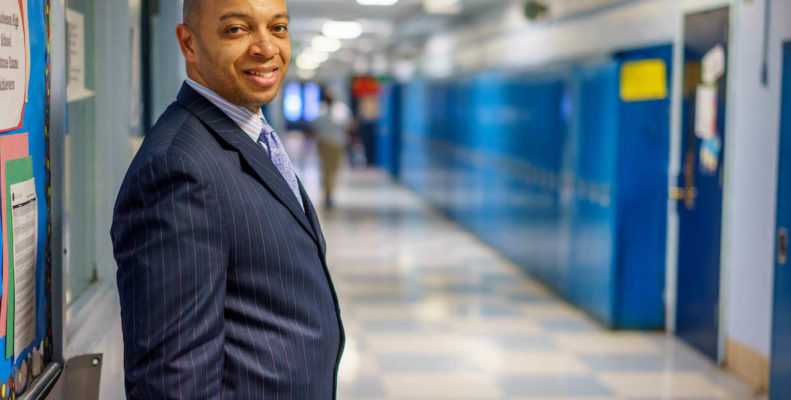 Richard Gordon, principal of Philadelphia's Robeson High School, poses next to lockers in the hallway at school