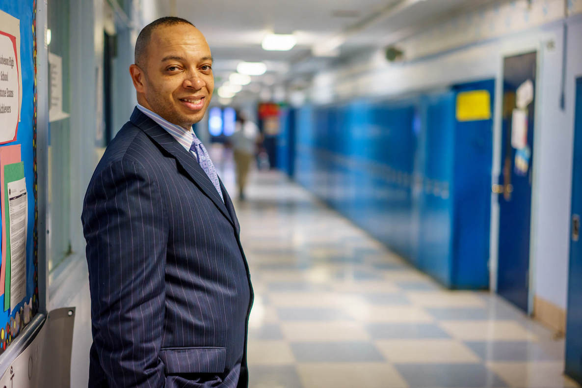 Richard Gordon, principal of Philadelphia's Robeson High School, poses next to lockers in the hallway at school