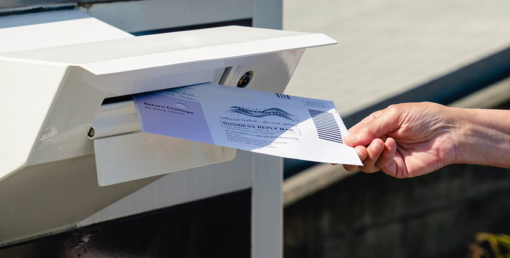A person puts their mail-in ballot in a drop box before Election Day 2020.