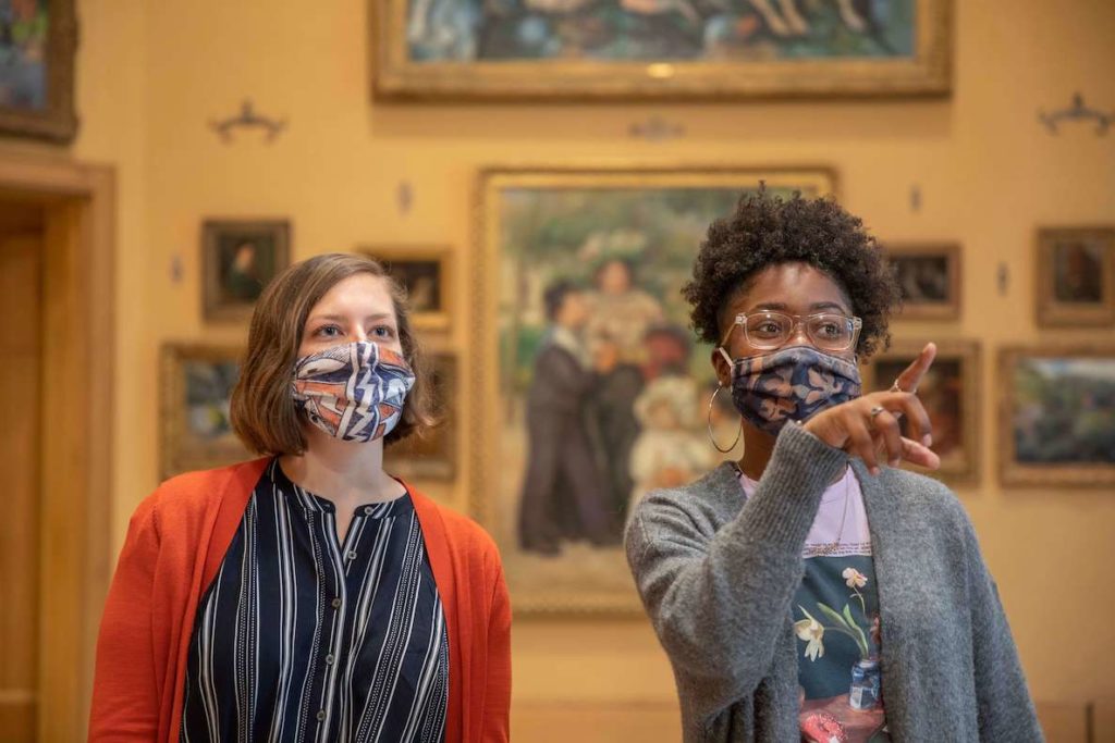 Two young women point at and discuss the world-renowned art at the Barnes Foundation in Philadelphia