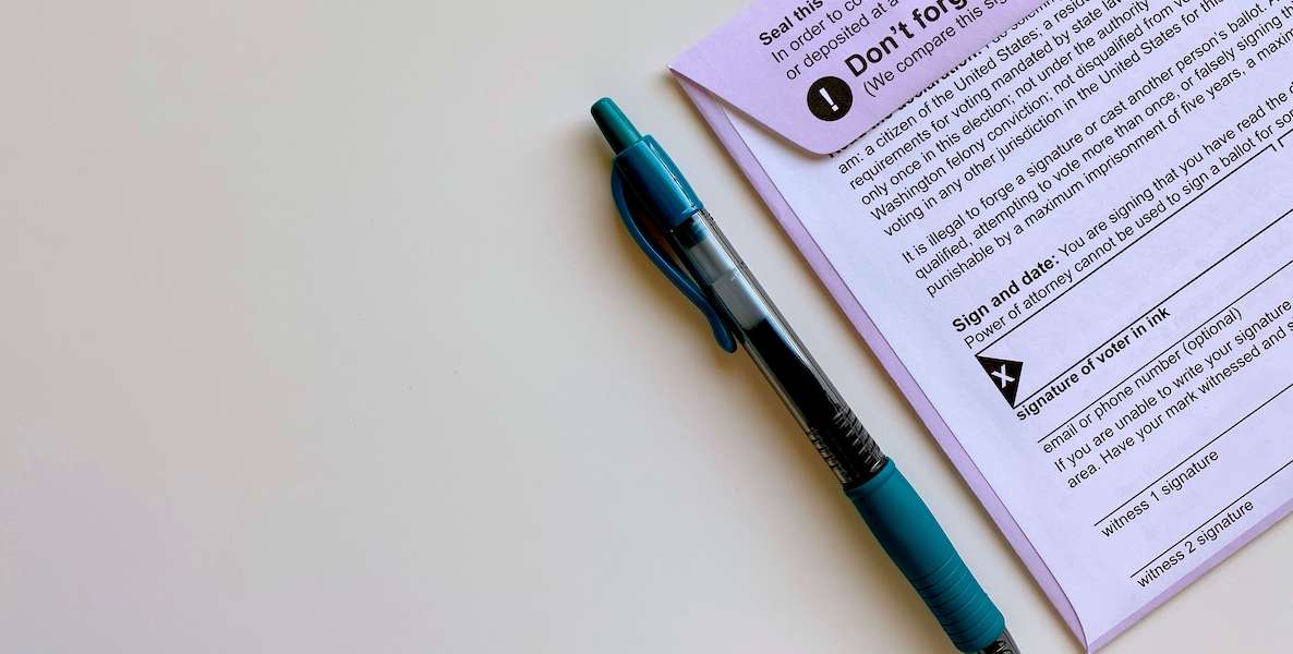 A pen and a ballot for someone voting by mail