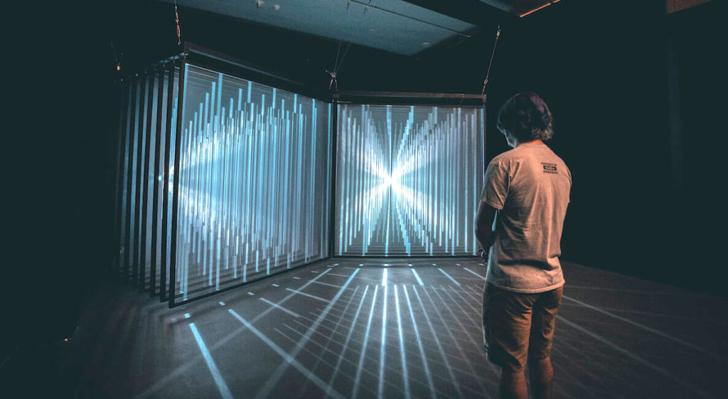 A guest checks out a glowing exhibition at Wonderspaces in Philadelphia