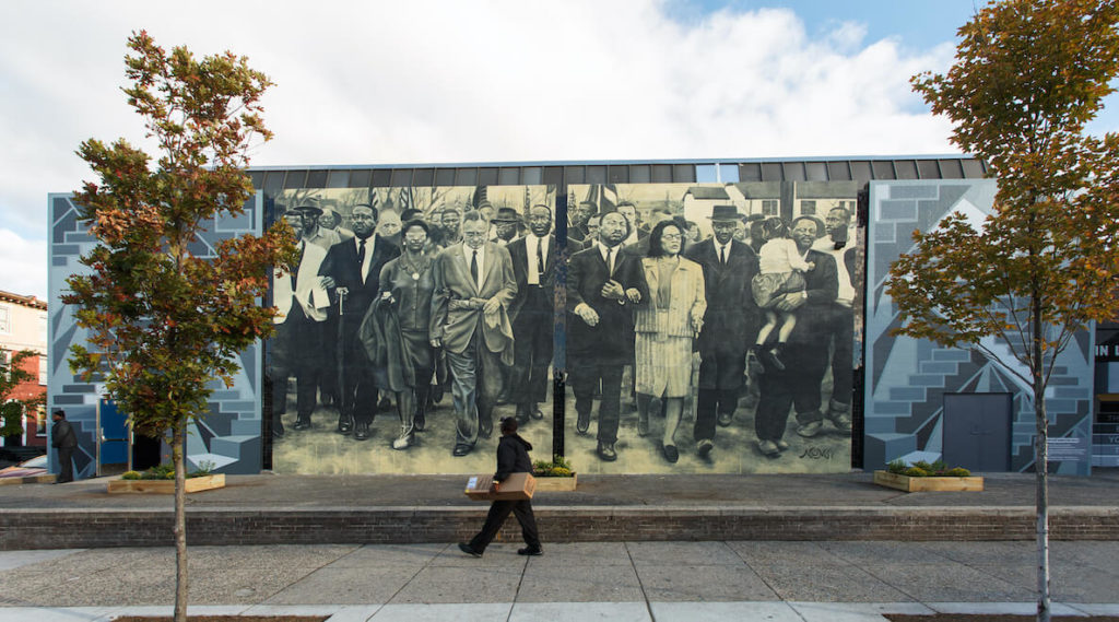 A man walks past a Martin Luther King Jr. mural in the beautiful city of Philadelphia