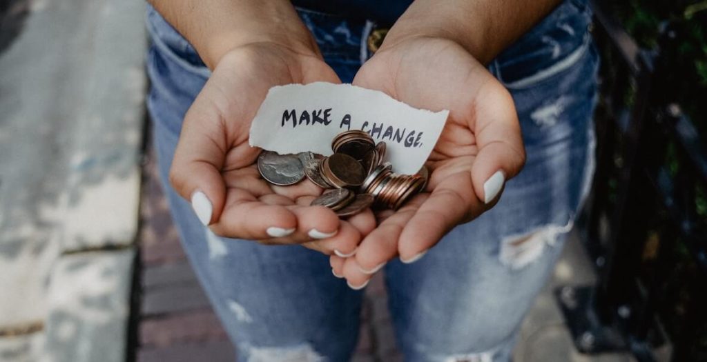 "make a change" woman's hands holding a pile of coins