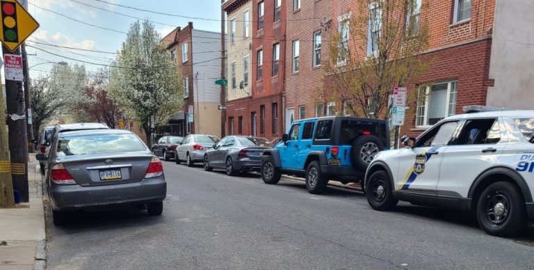 South Philadelphia block with parked cars and police vehicle