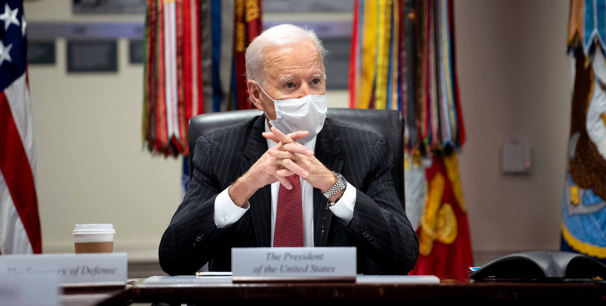 Joe Biden sits at a desk talking about his new infrastructure plan