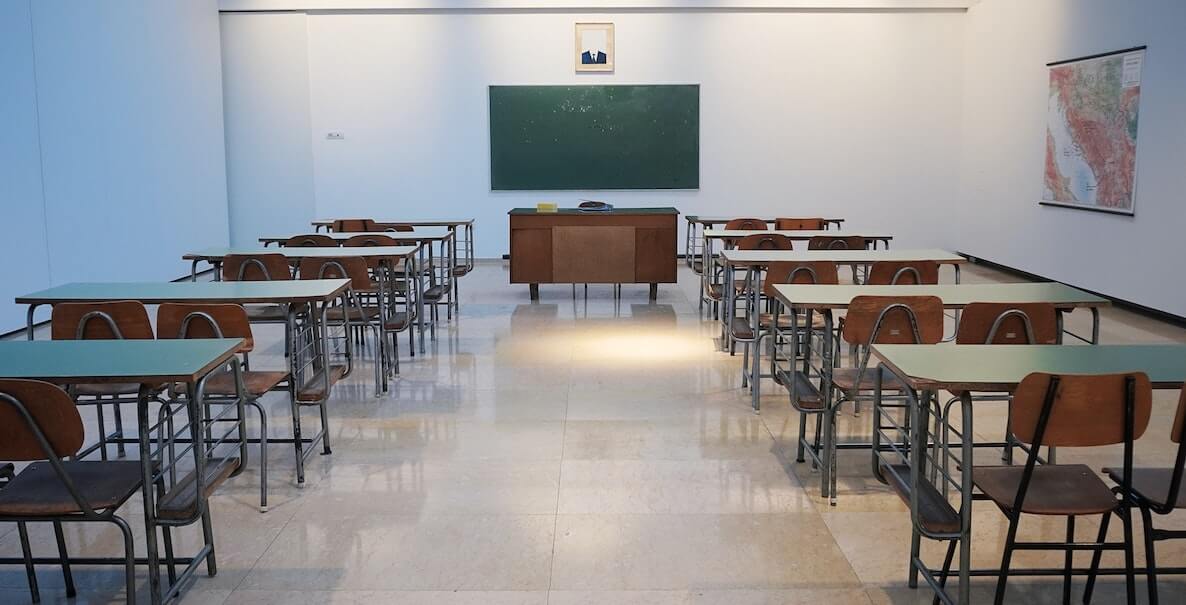 Empty classroom with desks, chairs and chalkboard