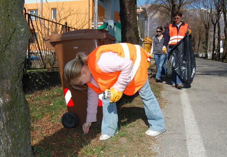 Neighbors picking up trash in bright orange vests