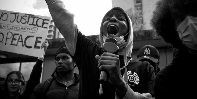 A woman speaks at a protest against police brutality in the wake of George Floyd's murder