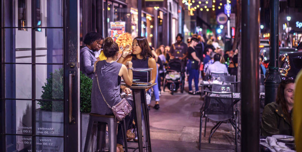Diners eat on outdoor tables along 13th Street in Midtown Village