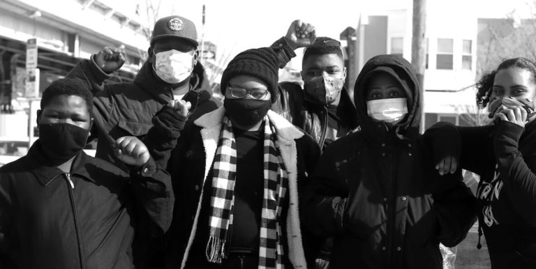 Young Black members of the ECO Foundation raise Black power fist