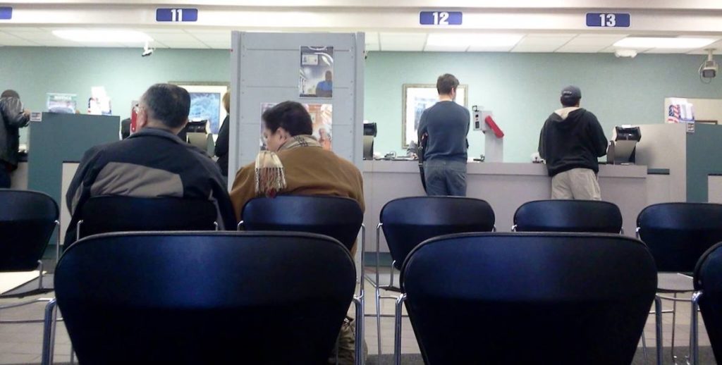 A photo of people waiting in line at the DMV office accompanies an article about how easy it is to get a Real ID in the state of Pennsylvania