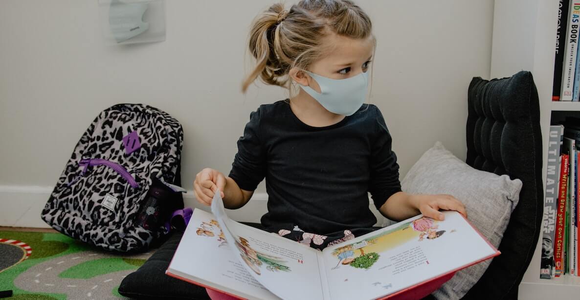 little girl reading with mask
