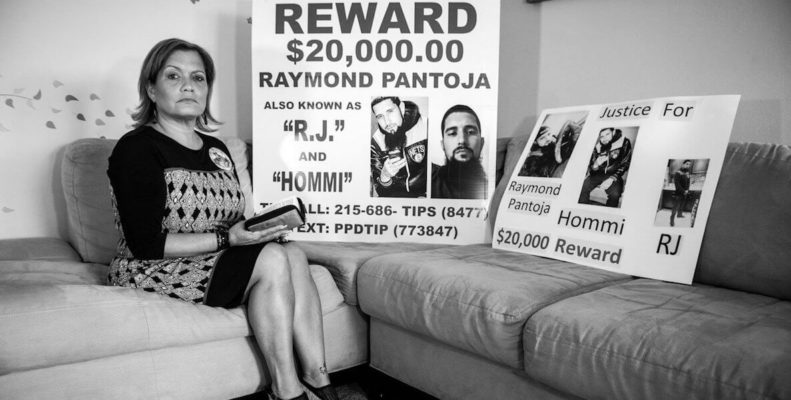 Lisa Espinosa sits with photos of her son Raymond Pantoja who was killed in Philly by gun violence