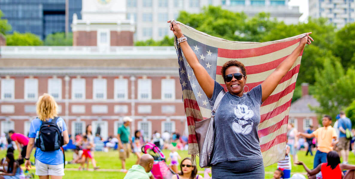 A woman waves an American flag in front of Independence Hall in Philadelphia