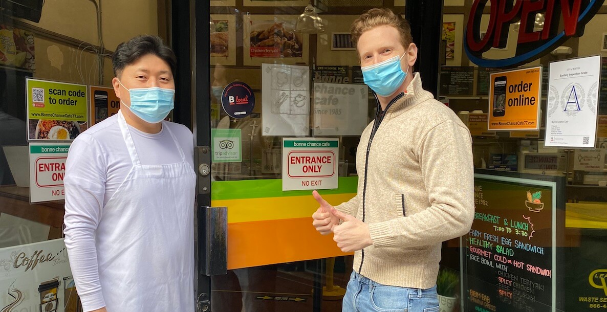 two men stand outside local business in Akron, Ohio wearing masks