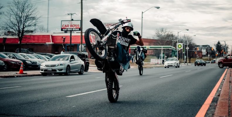 urban dirt biker pops a wheelie