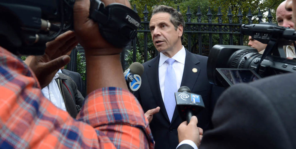 This photo of Andrew Cuomo surrounded by reporters accompanies an opinion piece about what one writer and editor learned from Cuomo's daughters after his fallout.