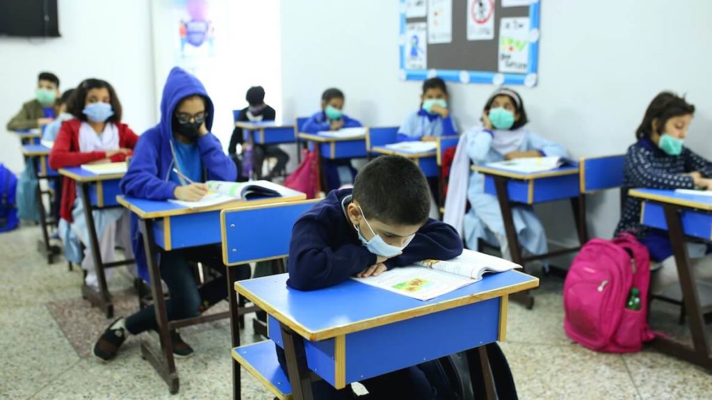 This photo of kids in a classroom wearing a mask accompanies an article about how to vaccinate kids