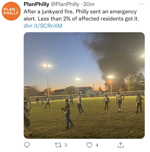 Kids playing soccer on field with smoke from tire fire 