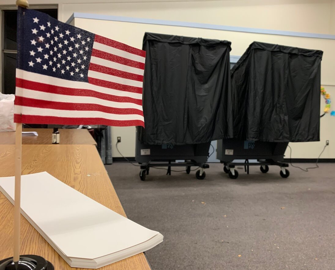 Voting booths, American flag, ballots