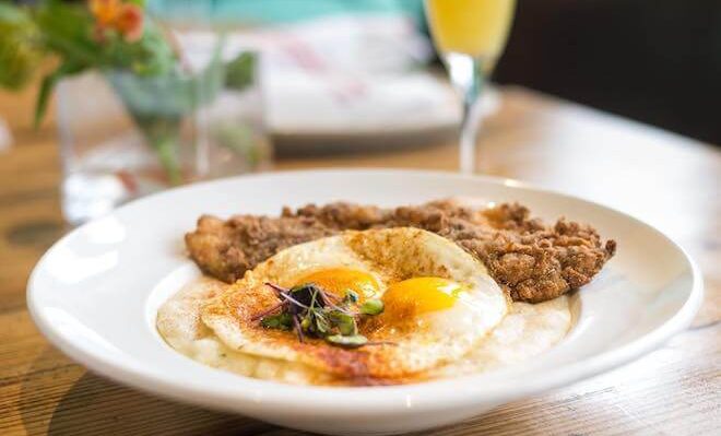 An egg (sunnyside up) and fried fish stand alongside a mimosa at Booker's Restaurant in West Philadelphia.