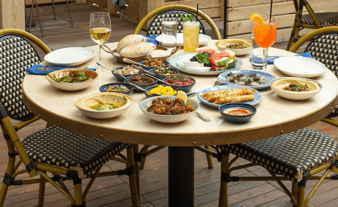 A table filled with food stands on the patio of Zahav, a popular Israeli restaurant in Philadelphia.