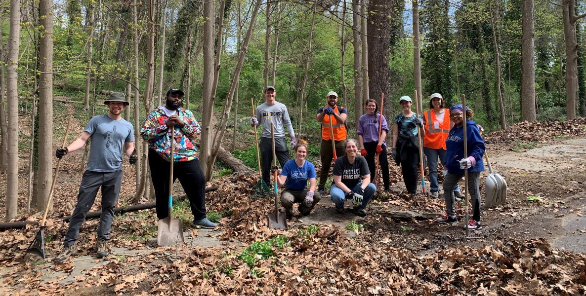 Volunteers in the Wissahickon Valley Park carry cleaning gear through the woods on Earth day to practice civic engagement.