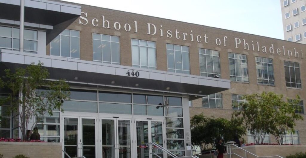 A low building bears the words "School District of." Beyond the "of" is "Philadelphia." This is their headquarters. 