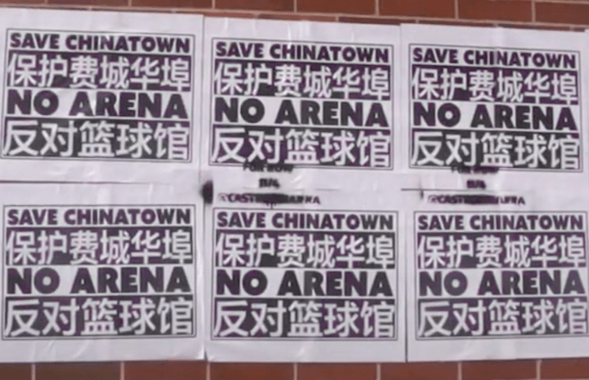 Signs reading "Save Chinatown No Arena" in English and Mandarin cover a brick wall.