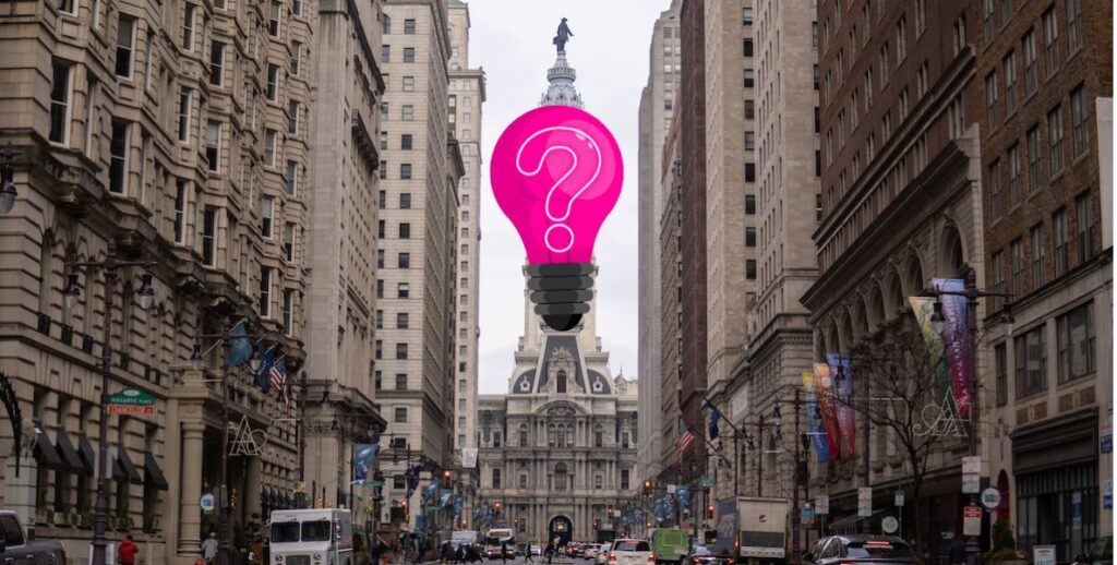 City hall adorned with a pink lightbulb symbolizing the ideas of city mayoral candidates