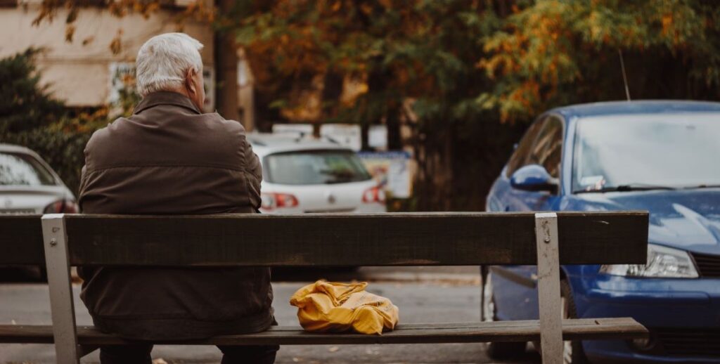 An older Philadelphia citizen sits on a city park bench