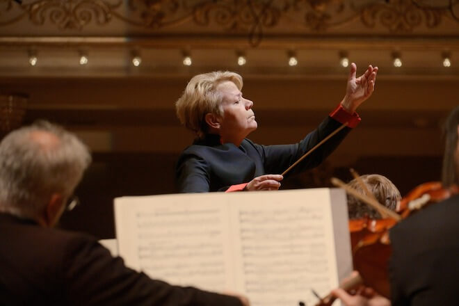 Conductor Marin Alsop conducts a philharmonic orchestra.