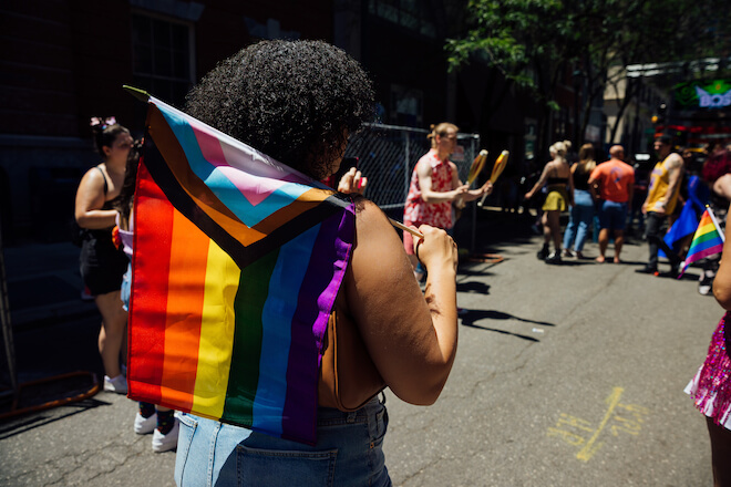A black person carries a Pride flag on a Philadelphia street as part of Pride.
