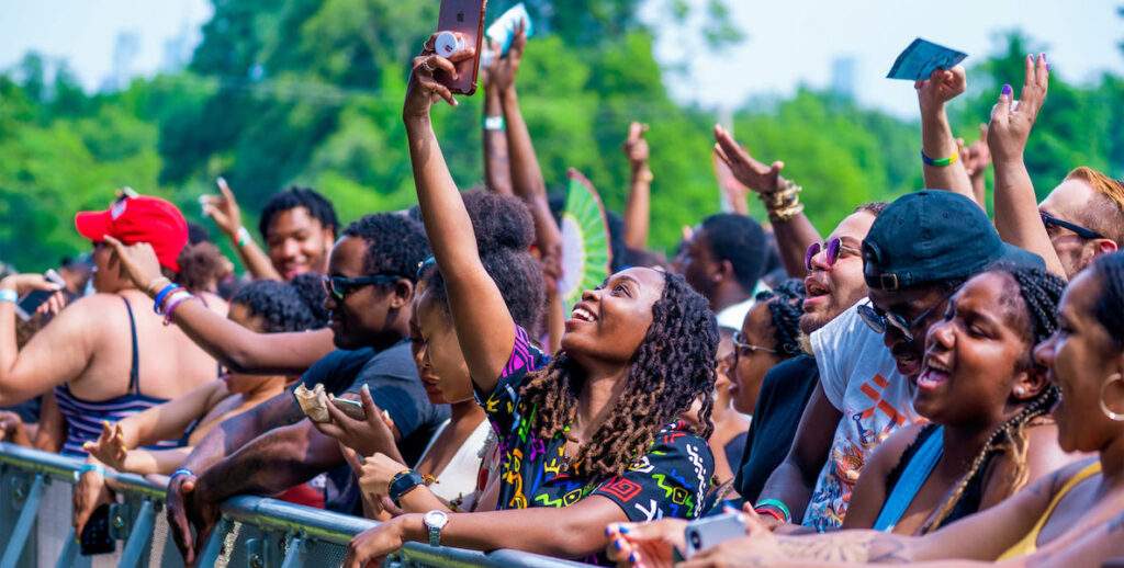 A crowd at The Roots Picnic in Philadelphia sings and snaps selfies.