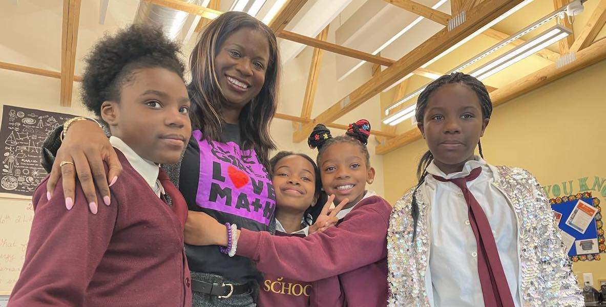 Local educator Atiyah Harmon, founder and executive director of Black Girls Love Math, surrounded by students before a math session at the St. James School in North Philadelphia.