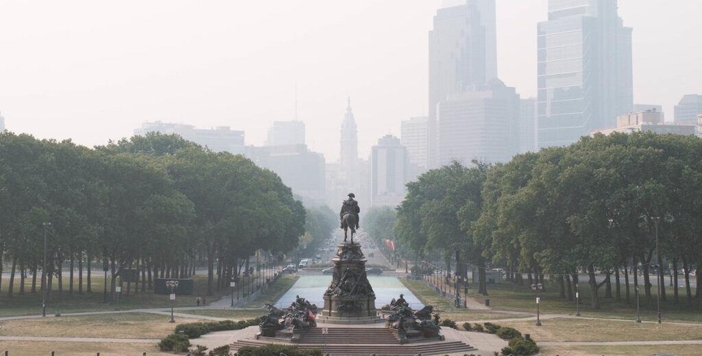 Smoke envelopes the skyline of Philadelphia, as viewed from Eakins Oval.