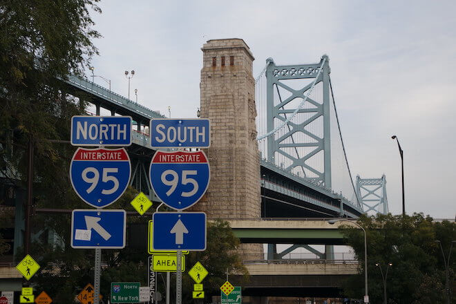 Blue and red street signs direct traffic to I-95 North and South near the Ben Franklin Bridge in Philadelphia.