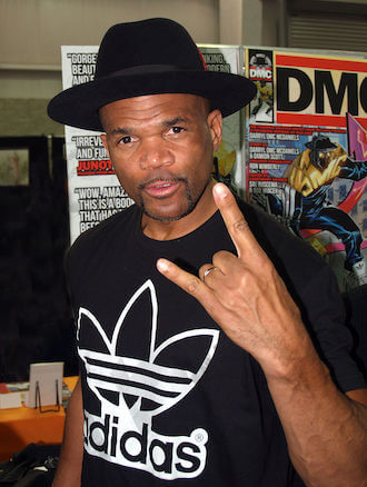 Iconic half of Run DMC, DMC is a hip hop and rap pioneer. Here, he wears a black ADIDAS t-shirt and signature black hat at a comic event.