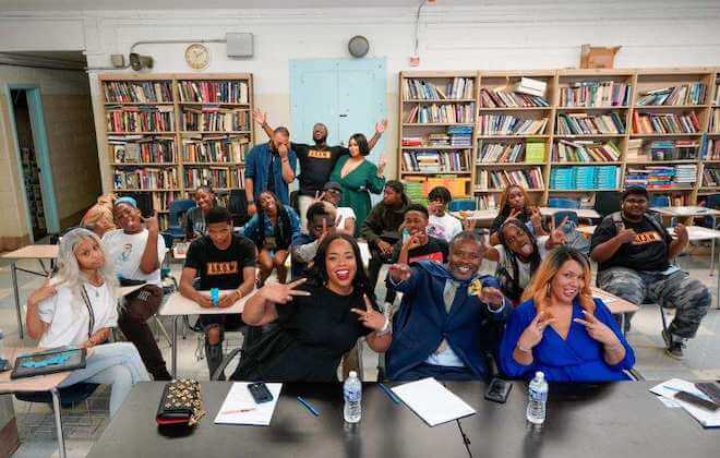 In a high school classroom, students of GROW Academy and Philadelphia business leaders pose for the camera.