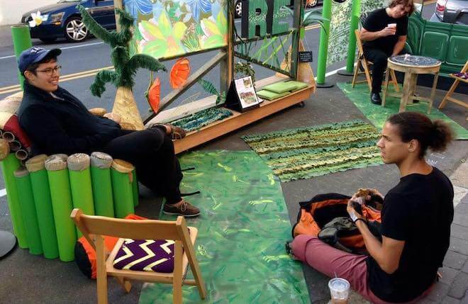 People sit among art in a parklet by The Resource Exchange on Park(ing) Day in Philadelphia 2014.